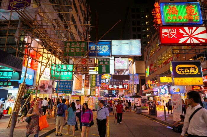 Hong Kong busy street scene at night with people and bright lights 