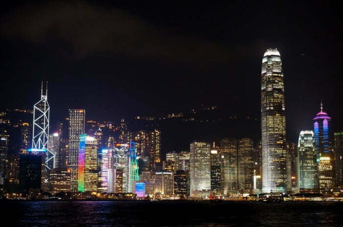 Victoria Harbour with the buildings lit up at night.