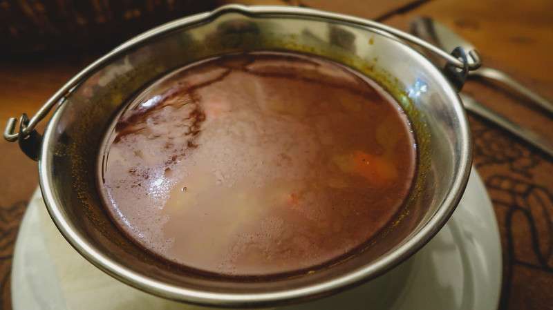 A bowl of goulash served in a metal bowl at Labirintus Restaurant A bowl of goulash served in a metal bowl at Labirintus Restaurant