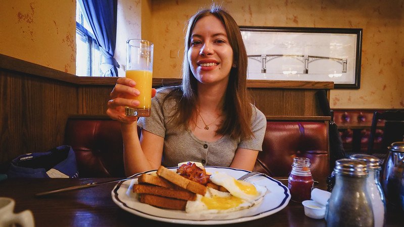 A hearty breakfast at The Arms Public House in Halifax, Nova Scotia being enjoyed by That Backpacker Audrey Bergner with orange juice in hand