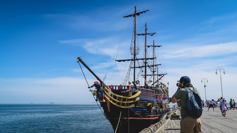 A tour of the harbour aboard a pirate ship in Sopot with Nomadic Samuel snapping photos before all aboard in Poland