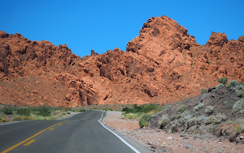 A wall of red sandstone rising up before the road in the Valley of Fire A wall of red sandstone rising up before the road in the Valley of Fire