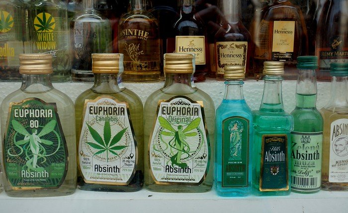 A shop display in Prague featuring bottles of absinthe, including traditional and cannabis-infused varieties, highlighting the city’s cultural association with the legendary green spirit and its appeal to curious travelers exploring Czech traditions
