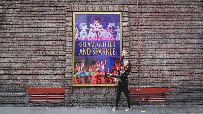 Aladdin in the West End as presented by That Backpacker Audrey Bergner inviting you to Gleam, Glitter and Sparkle against brick wall in London, England 