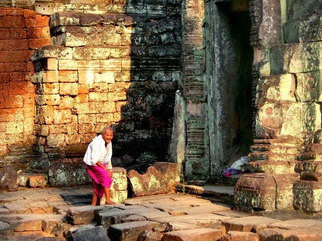 An elderly man strolls the temple grounds at the temples of Angkor, Cambodia