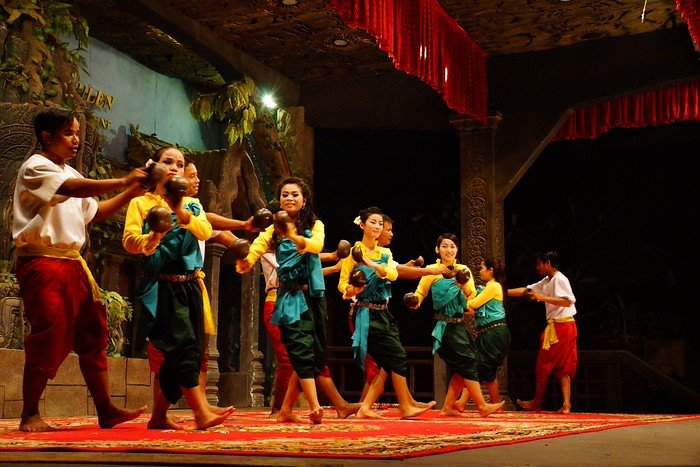 Traditional Apsara Dance performance in Siem Reap, Cambodia, featuring Khmer dancers in vibrant costumes gracefully moving in unison on a decorated stage