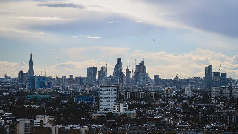 Panoramic view of London’s skyline from the ArcelorMittal Orbit in Queen Elizabeth Olympic Park, featuring iconic skyscrapers like The Shard, The Gherkin, and the Walkie Talkie building rising above the city’s mix of modern and historic architecture