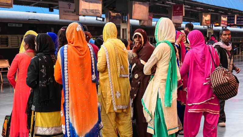 At the train station in Jodhpur with a group of ladies wearing the brightest coloured saris that were diverse in colour in India 