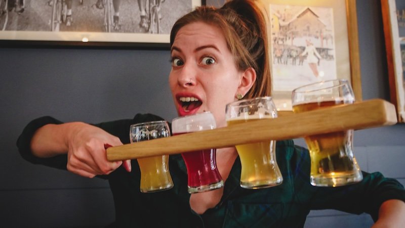 That Backpacker Audrey Bergner enthusiastically holding a colourful flight of craft beers at a local microbrewery in Sutton, Quebec’s Eastern Townships
