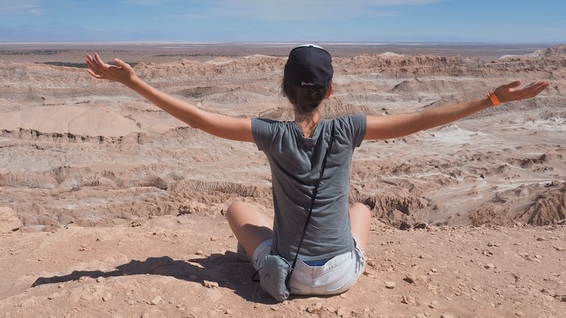 That Backpacker Audrey Bergner sitting with arms outstretched while admiring the dramatic desert landscapes of Valle de la Luna in Chile’s Atacama Desert That Backpacker Audrey Bergner sitting with arms outstretched while admiring the dramatic desert landscapes of Valle de la Luna in Chile’s Atacama Desert