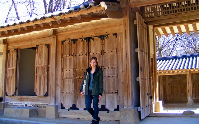 Audrey living and teaching ESL in Korea visiting one of Seoul's palaces in winter with That Backpacker Audrey Bergner standing outside in the snow in South Korea