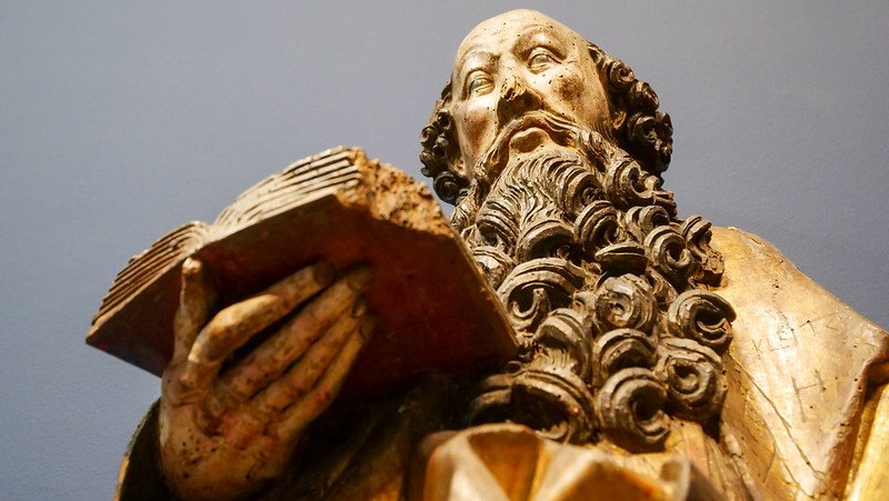 Close-up of a finely carved medieval statue holding an open book, part of the Augustiner Museum collection in Freiburg im Breisgau, Germany, showcasing religious sculptures originally from Freiburg Cathedral