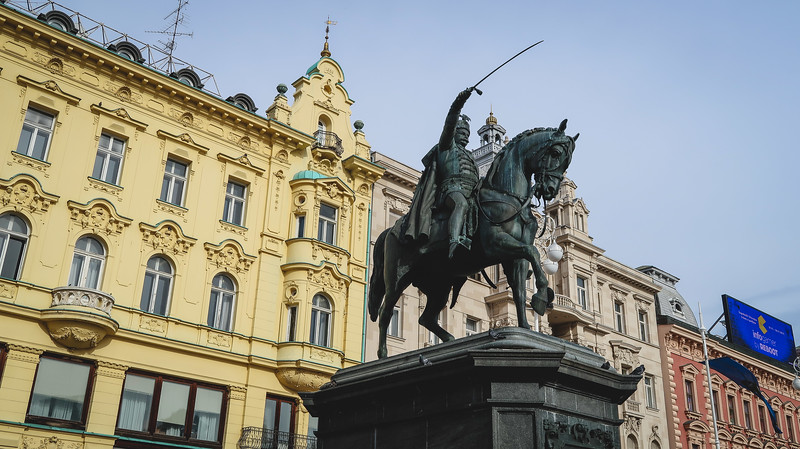 Ban Jelačić Square in Zagreb with distinct monuments in the foreground and beautiful architecture in the background in Croatia