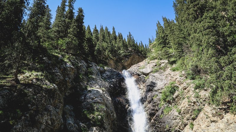 Barskoon Gorge and Waterfalls with dense forest and rugged rocky scenery in Kyrgyzstan 