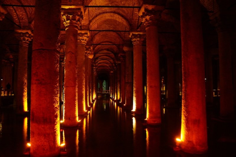 Dramatically lit stone columns reflected in the still waters of the Basilica Cistern, an ancient underground reservoir and popular historical attraction in Istanbul, Turkey