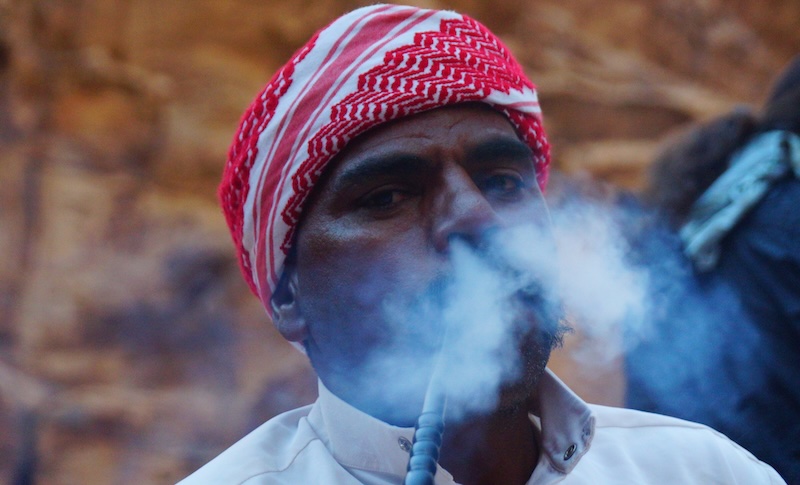 Bedouin man blowing smoke from his nose in Wadi Rum macro details adventure travel in Jordan 