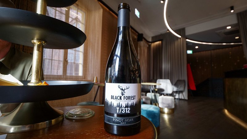 A bottle of Black Forest T/312 Pinot Noir dry red wine displayed on a table during a wine tasting in Freiburg im Breisgau, Germany, showcasing local Black Forest wines