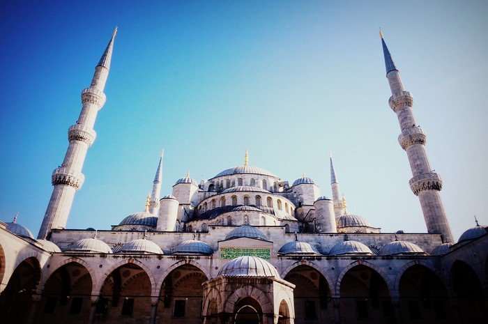 The majestic Blue Mosque (Sultan Ahmed Mosque) in Istanbul, Turkey, showcasing its grand domes and towering minarets against a clear blue sky