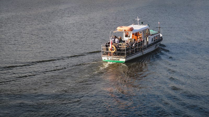 Boat tour in Krakow watching it ply the river from a high vantage point in Poland Boat tour in Krakow watching it ply the river from a high vantage point in Poland