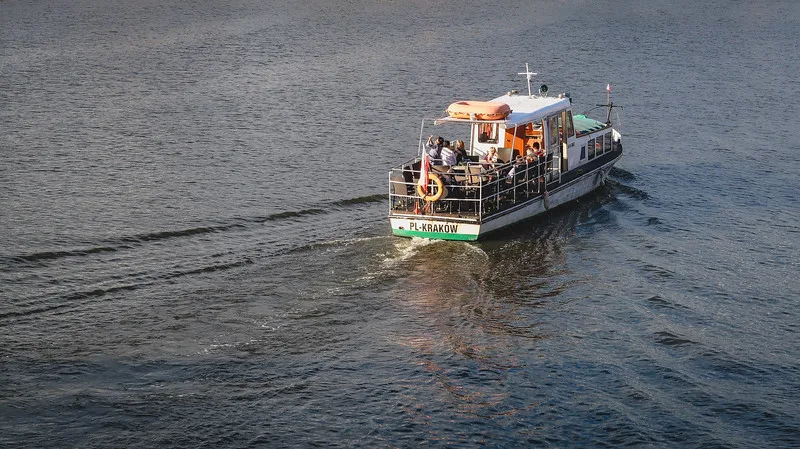 Boat tour in Krakow watching it ply the river from a high vantage point in Poland Boat tour in Krakow watching it ply the river from a high vantage point in Poland