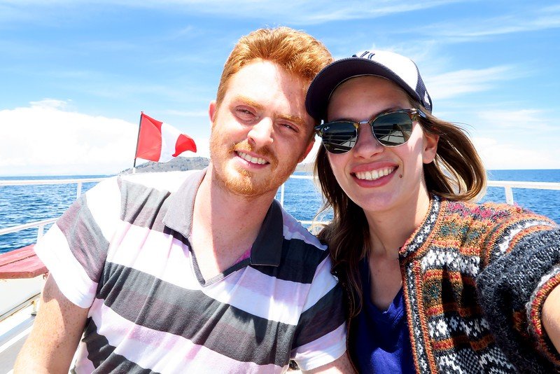 Boat trip on Lake Titicaca, Peru on a beautiful sunny day with Nomadic Samuel and Audrey Bergner That Backpacker with big happy smiles 
