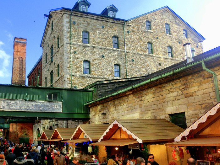Booths selling all kinds of Christmas treats with historic backdrop in Toronto for the winter market in Ontario, Canada 