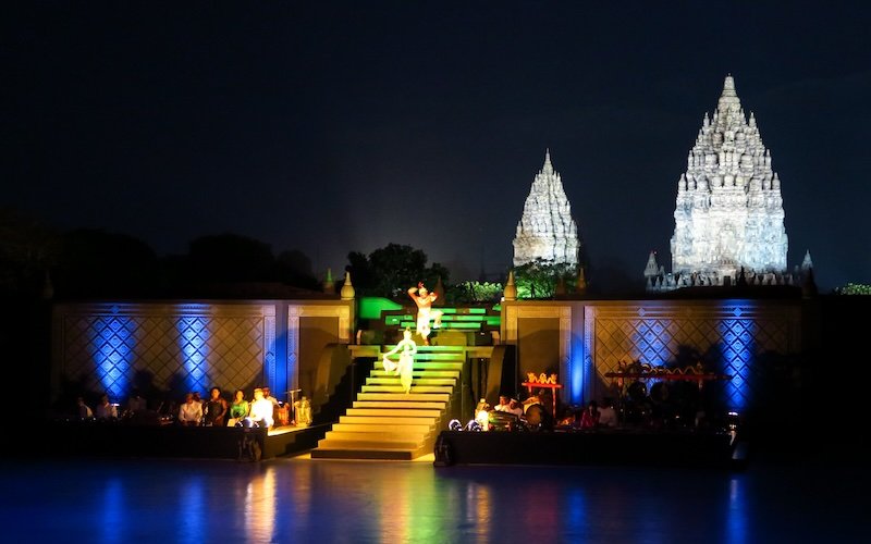 Borobudur all lit up at night and colorful performers wearing traditional clothes 