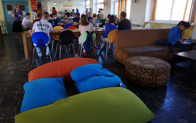 Breakfast at Abraham Hostel Jerusalem, Israel with social seating arrangements at the tables and also lounging area with comfy bag sofas