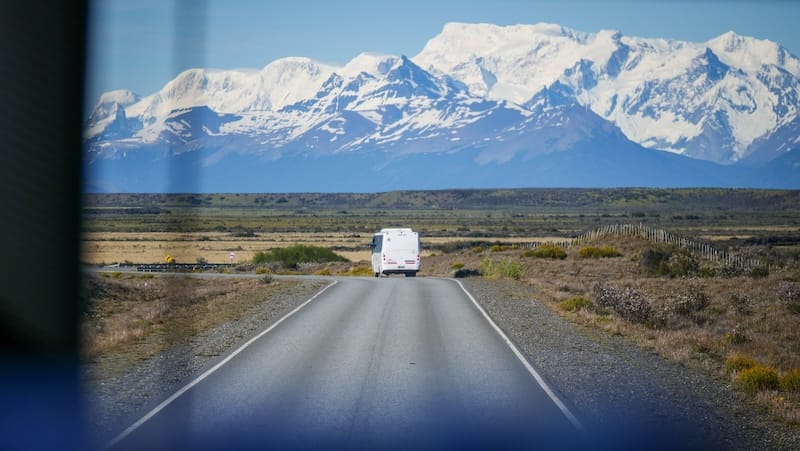 Bus turning sharply with mountain backdrop in South America 
