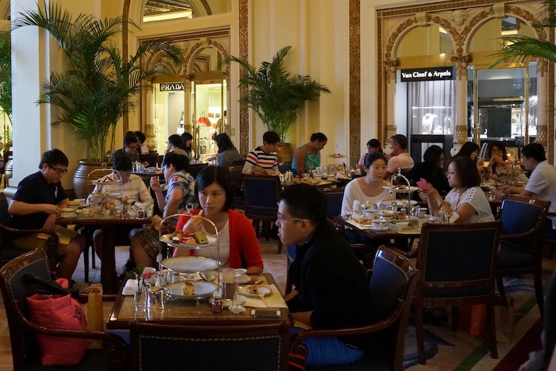 Busy scene inside the Peninsula for afternoon tea in Hong Kong with all tables full Busy scene inside the Peninsula for afternoon tea in Hong Kong with all tables full
