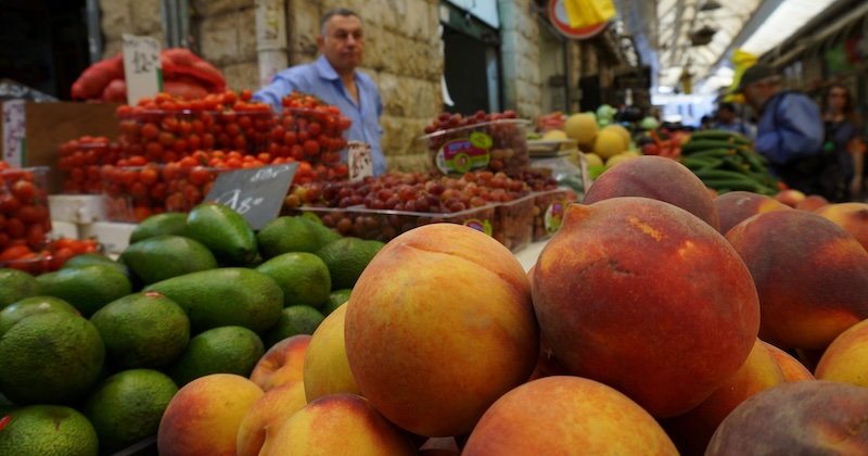 Buying fresh fruit from Mahane Yehuda Market in Jerusalem, Israel as a DIY grocery shopping vs dining out to save on a budget experience Buying fresh fruit from Mahane Yehuda Market in Jerusalem, Israel as a DIY grocery shopping vs dining out to save on a budget experience