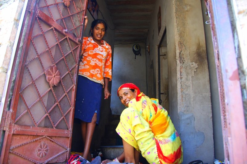 Candid photos of local ladies smiling in Jodhpur, India standing outside of the door 