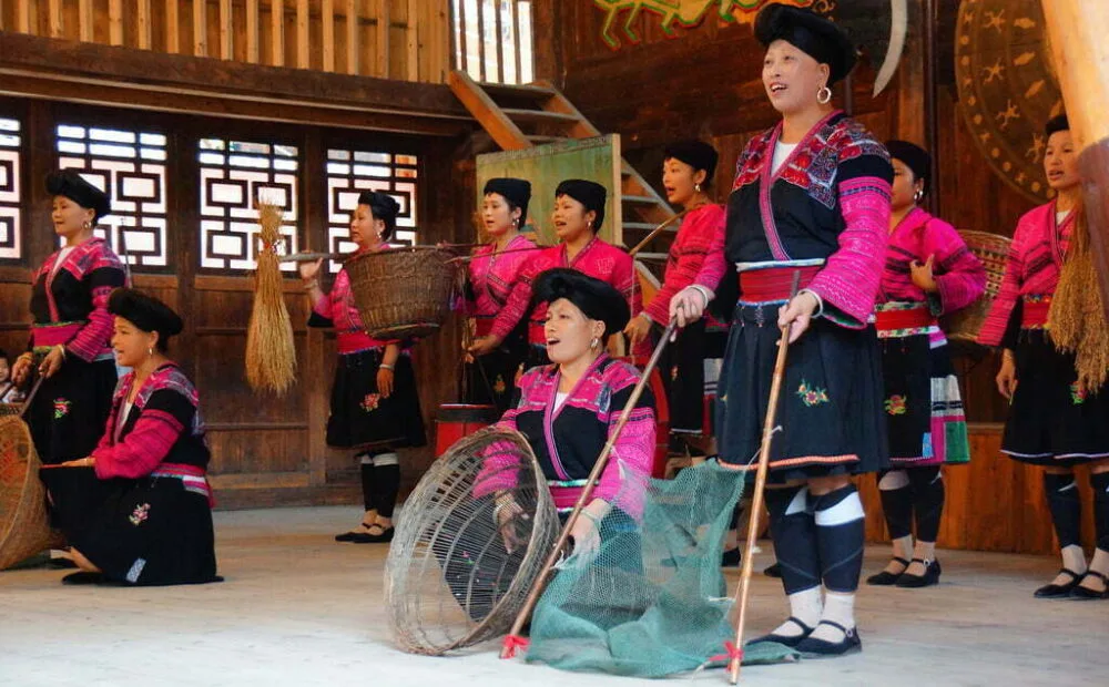 Ceremonial dance from the Long Hair Red Yao Hill Tribe In China using traditional nets and baskets as part of the performance for guests 