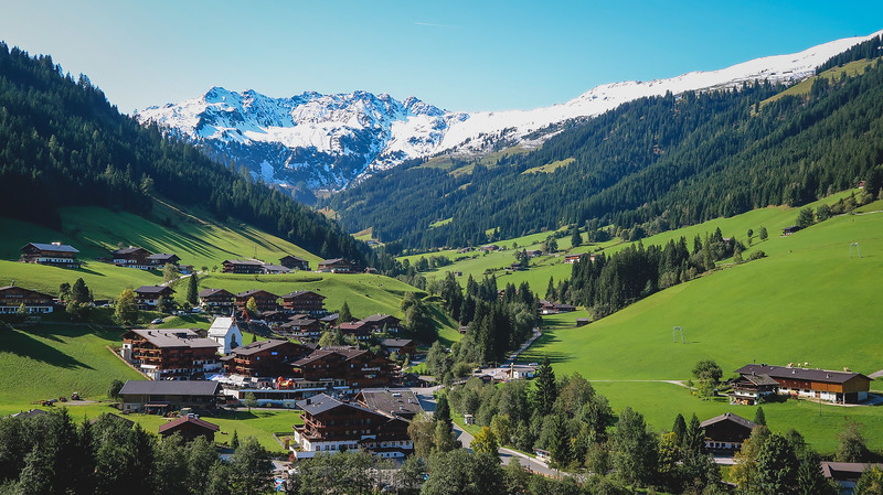 Charming little villages in Tyrol with Alpine valley views and distinct regional architecture and snowcapped mountains in the background