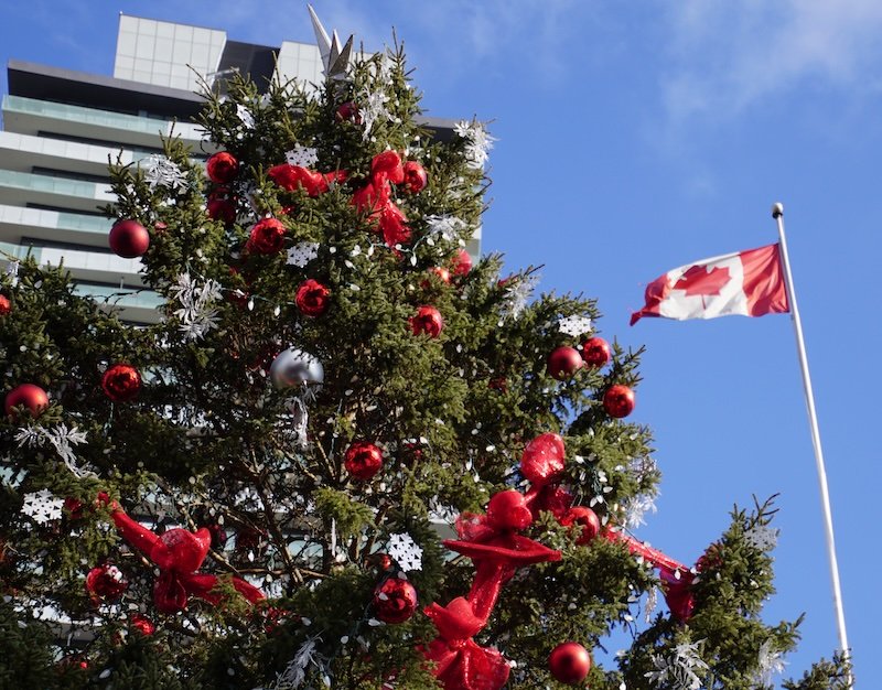 Christmas tree all decorated and Canada flag side by side at the Toronto Christmas Market 