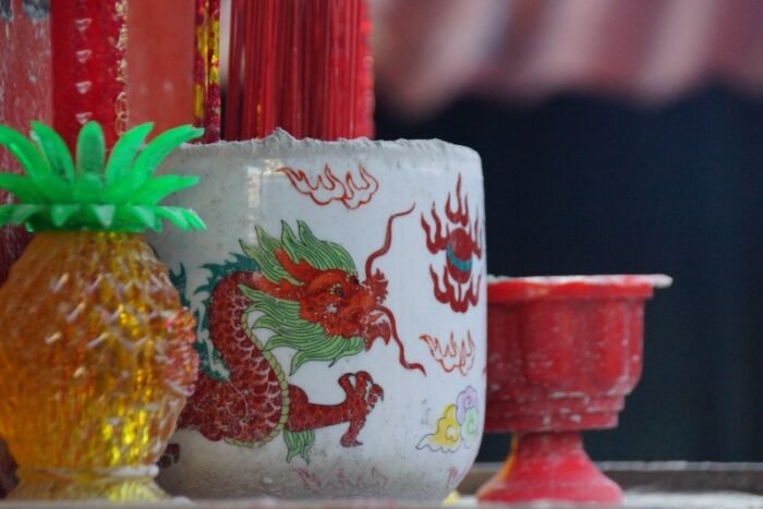 Incense sticks burning in a dragon-decorated ceramic holder at the Clan Jetties in Georgetown, Penang, Malaysia, showcasing Chinese cultural traditions
