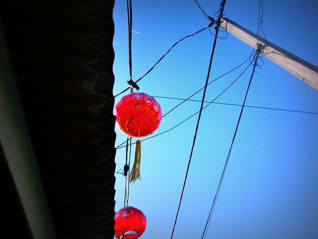 Traditional red Chinese lanterns hanging above the wooden houses at the Clan Jetties in Georgetown, Penang, Malaysia, symbolizing cultural heritage
