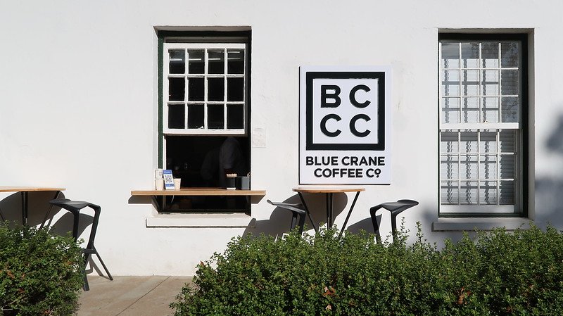 Coffee at the Blue Crane Coffee Company in Stellenbosch with its minimalist logo and simple tables outside of the shop offering a place to enjoy your beverage