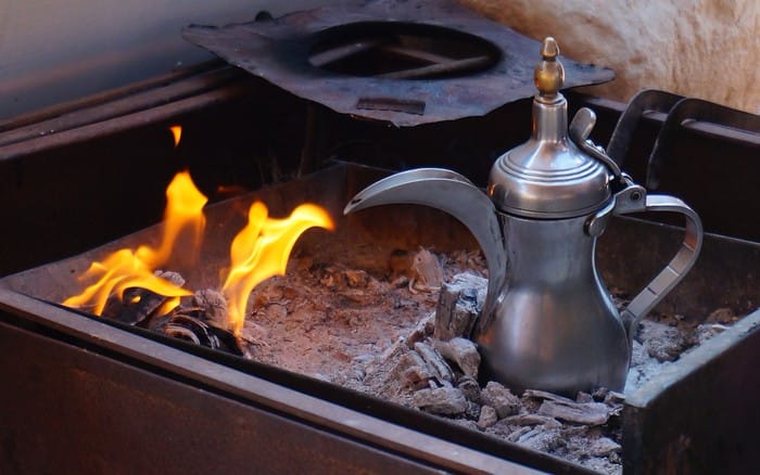 Coffee time the Bedouin way cooked and warmed beside a fire in Jordan in a traditional pot