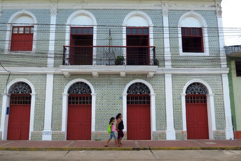 Colonial architecture and pedestrians walking by in Iquitos, Peru 