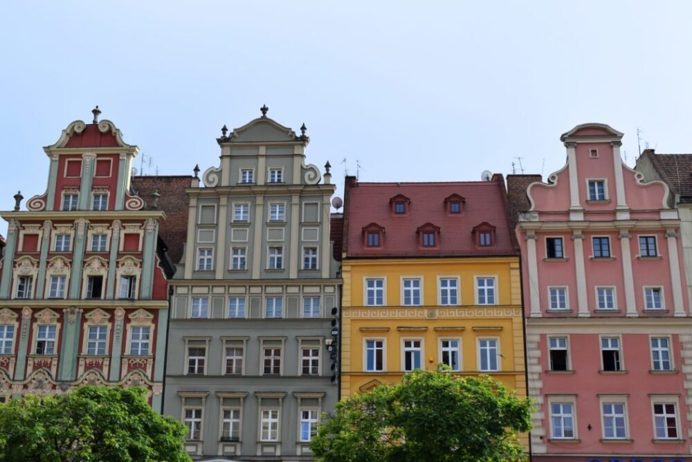 Colorful buildings in the downtown of Wroclaw, Poland with yellows, pinks and greens on display and adding plenty of charm