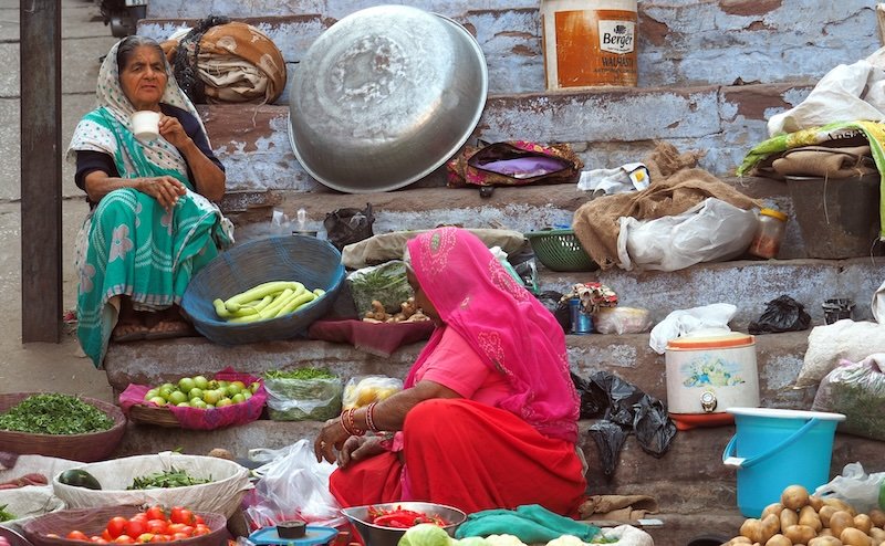 Colorful wet market scene in Jodhpur with ladies wearing saris selling fruits and vegetables 