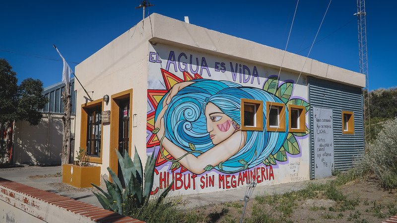 Brightly painted storefronts and restaurants line the main street of Puerto Pirámides, Patagonia, Argentina. The vivid red, teal, and brown facades reflect the town’s quirky charm and laid-back atmosphere, inviting visitors to explore on foot