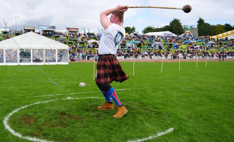 Competing in heavy athletics with a man showcasing his immense strength in Dunoon