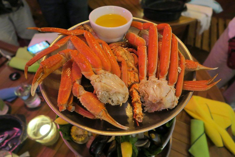 Crab legs and lobster at The Stoned Crab served on traditional stacking plates with absolutely giant portions on offer and warm butter in the Florida Keys