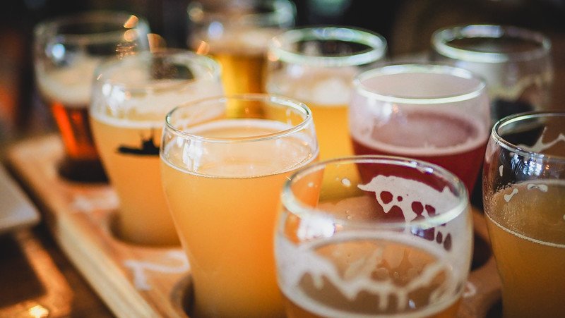 A close-up of a vibrant craft beer flight featuring a variety of golden, amber, and red ales at À L’Abordage Microbrasserie in Sutton, Quebec, highlighting the local brewing culture of the Eastern Townships.