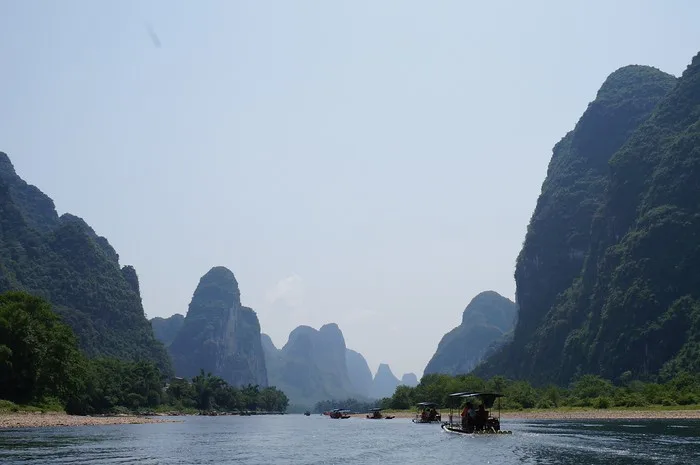 Cruising down the Li River with Karst mountain views and boats off in the distance on a day where we had great weather that day in China