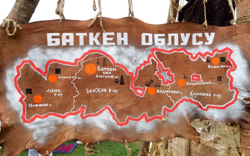Cyrillic sign in Kyrgyzstan highlighting a map and place of attraction and a path