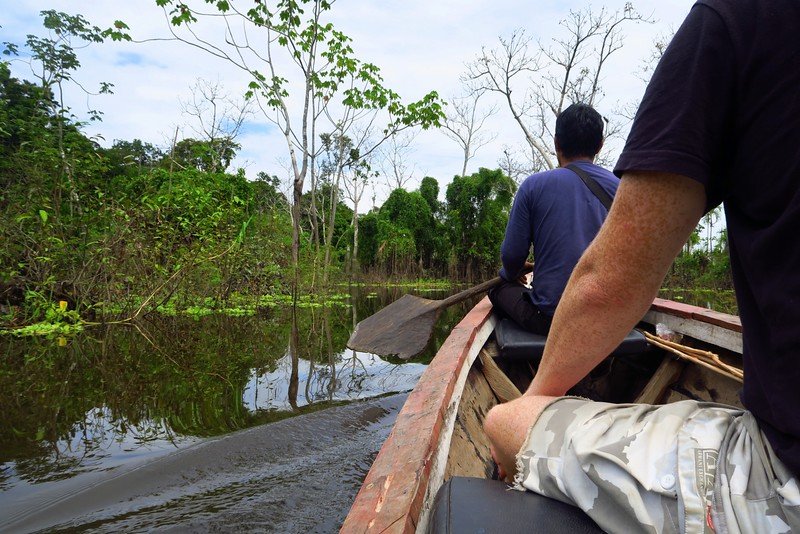 Doing on excursions in the Amazon Jungle in Peru is Nomadic Samuel at boat level with a guide up front paddling