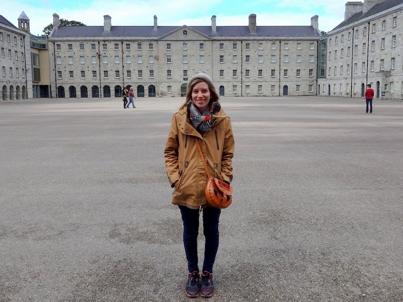 Dressed for cold atmospheric weather in Dublin, Ireland is That Backpacker Audrey Bergner bundled up from head to toe with warm jacket and beanie hat on head 